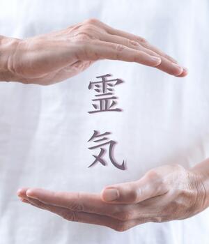 deux mains qui entoure le symbole Reiki